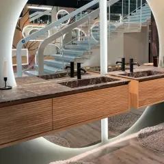 Une belle idée salle de bain marbre avec des meubles en bois et un grand miroir circulaire.