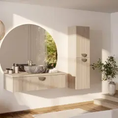 Une salle de bain moderne et chic avec un lavabo en pierre, un miroir rond lumineux et une armoire en bois clair. La lumière naturelle filtre à travers une fenêtre circulaire.