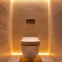 Une toilette suspendue blanche, nichée dans un alcôve aux murs de pierre, avec un éclairage LED subtil pour une deco wc moderne et apaisante.
