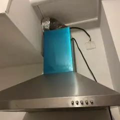 Hotte aspirante en inox avec conduit d'évacuation argenté. Il est temps de nettoyer filtre hotte pour une cuisine plus saine.