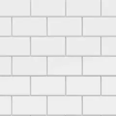 Vue rapprochée d'une pose carrelage métro blanche, avec des carreaux rectangulaires disposés en quinconce.
