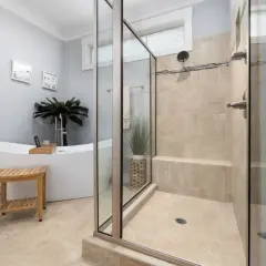 Salle de bain moderne avec baignoire îlot et douche à l'italienne carrelée. Une belle idee salle de bain douche pour un espace zen.