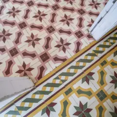 Un beau mélange de travertin et de carreaux de ciment aux motifs géométriques et floraux, créant une ambiance chaleureuse et authentique.