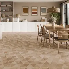 Un salon lumineux avec un carrelage non salissant au motif géométrique discret. Une table en bois et des chaises en rotin complètent l'ensemble.