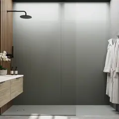 Salle de bain moderne avec lavabo en bois, douches et peignoirs. Le receveur de douche, discret, s'intègre parfaitement.
