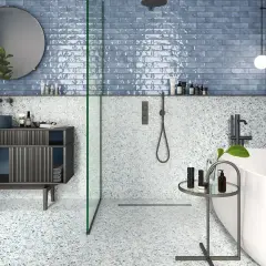 Salle de bain moderne avec carrelage mural bleu brillant et sol terrazzo. La taille du carrelage mural salle de bain est rectangulaire, créant un effet de profondeur.