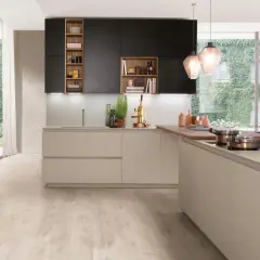 Une cuisine moderne avec des armoires noires et beiges, un îlot en bois et une grande fenêtre donnant sur un mur végétal. Une belle cuisine inspiration pour votre intérieur.