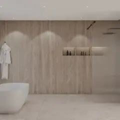 Élégante salle de bain beige et blanc avec baignoire îlot, douche vitrée et peignoir blanc suspendu.