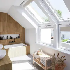 Salle de bain sous pente lumineuse avec murs en bois, baignoire, double vasque et grandes fenêtres de toit offrant une vue sur un jardin.