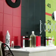 Un mur de salle de bain aux carreaux rouges, noirs et verts, avec des marques de croissance. Une inspiration peinture céramique pour un décor audacieux.