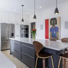 Exemple de cuisine moderne avec îlot central gris, chaises en bois courbé, tableau abstrait et tulipes rouges.