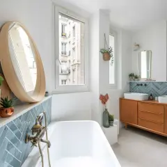 Salle de bain moderne avec baignoire, double vasque sur meuble vintage et carrelage mural en zellige bleu canard.