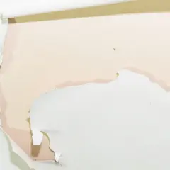 Détail d'une peinture qui s'écaille sur un mur, révélant une couche inférieure rosée. Des lambeaux blancs se détachent, laissant apparaître des traces d'humidité.