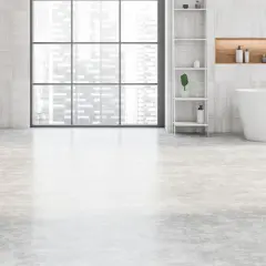 Salle de bain moderne avec baignoire îlot, double vasque et étagères. Le sol de la salle de bain est en béton ciré clair, apportant une touche contemporaine.