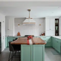 Cuisine moderne avec îlot en bois, armoires vertes et blanches. Idée pour refaire sa cuisine petit budget.