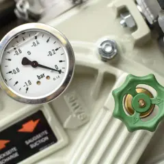 Manomètre indiquant la pression sur un appareil industriel, avec une valve verte et une étiquette "SAUGSEITE SUCTION". Ce **reducteur de pression** est essentiel.