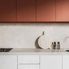 Crédence derrière plaque de cuisson gaz, avec un plan de travail en marbre clair, des placards cuivrés et un évier moderne.