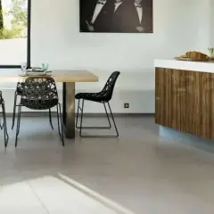 Un salon moderne avec une table en bois, des chaises noires design et un îlot de cuisine en bois. Le sol en carrelage clair complète l'ensemble.