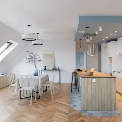 Un espace de vie lumineux avec carrelage cuisine ouverte et parquet salon en chevrons. Une table à manger est dressée, prête pour un repas convivial.