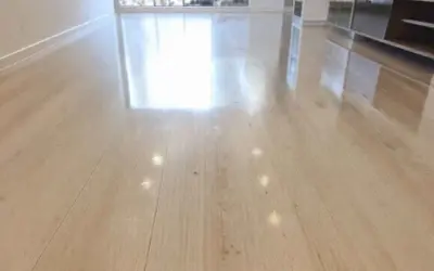 Un sol en bois clair, lustré et sans traces, reflétant la lumière. Un résultat impeccable pour nettoyer carrelage brillant sans trace.