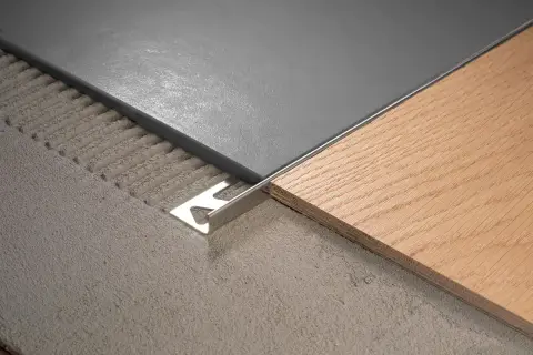 Le sol présente 2 carrelages différents : un gris moderne et un imitation bois chaleureux, séparés par une plinthe métallique.