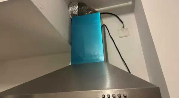 Hotte aspirante en inox avec conduit d'évacuation argenté. Il est temps de nettoyer filtre hotte pour une cuisine plus saine.