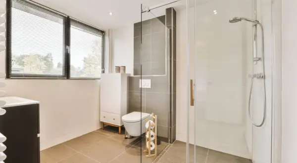 Salle de bain moderne avec douche italienne surélevée avec marche, toilettes suspendues et meuble vasque.