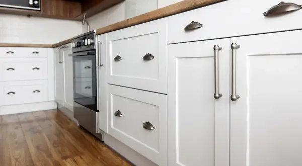 Cuisine moderne avec meubles blancs et poignées argentées. Un projet de rénovation de meuble cuisine réussi, alliant style et fonctionnalité.