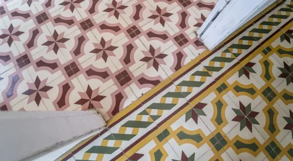 Un beau mélange de travertin et de carreaux de ciment aux motifs géométriques et floraux, créant une ambiance chaleureuse et authentique.
