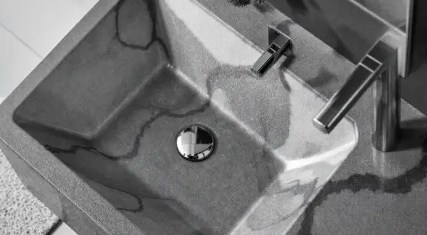 Lavabo évier moderne en béton gris veiné, avec robinetterie chromée. Un design épuré pour une salle de bain contemporaine.
