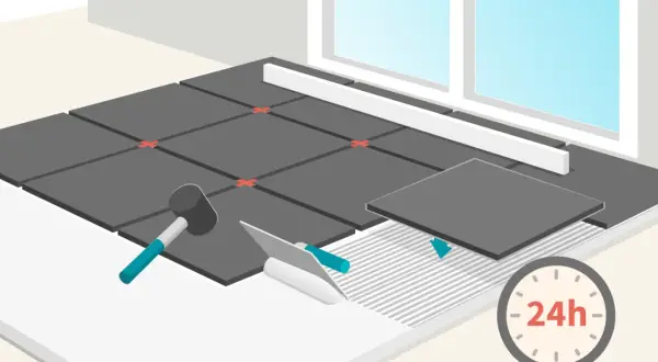 Pose de carrelage au ciment : une nouvelle dalle est posée sur la colle fraîche. Un marteau et une spatule sont prêts. Le séchage prend 24h.