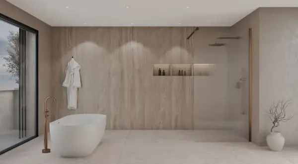 Élégante salle de bain beige et blanc avec baignoire îlot, douche vitrée et peignoir blanc suspendu.
