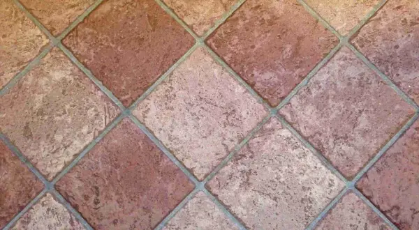Carrelage mal posé, les carreaux de terre cuite sont de travers, créant un motif irrégulier et déroutant.