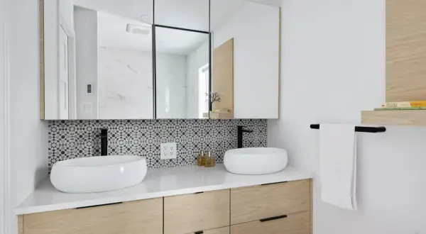 Meuble de salle de bain moderne avec deux vasques, carrelage géométrique et tiroirs en bois clair. Une belle idée meuble salle de bain à faire soi-même.