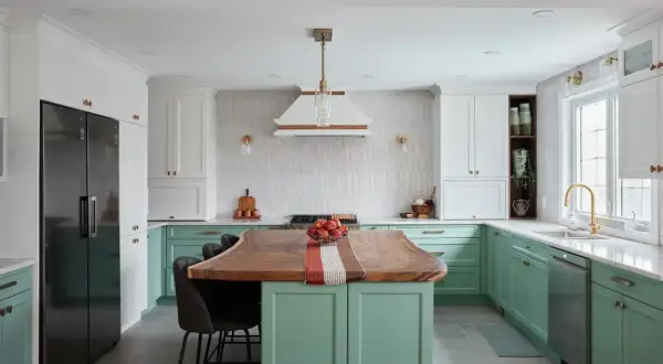 Cuisine moderne avec îlot en bois, armoires vertes et blanches. Idée pour refaire sa cuisine petit budget.