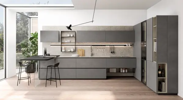 Plan cuisine en L moderne, gris, avec îlot, tabourets et grandes fenêtres.