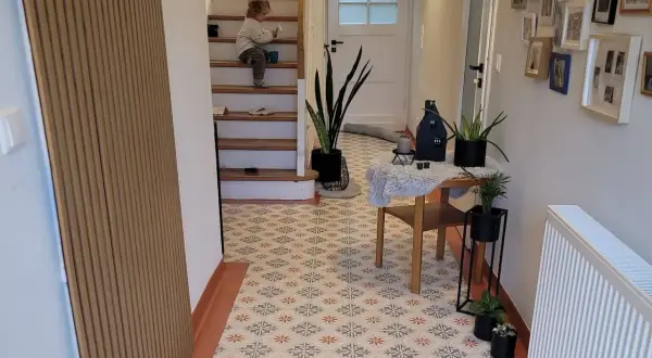 Un enfant sur les escaliers, un sol aux motifs floraux. Avis sur la peinture sur carrelage : un rendu chaleureux et moderne.