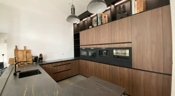 Cuisine salle à manger et salon dans la même pièce. Design moderne avec îlot central, meubles en bois, et électroménagers intégrés.