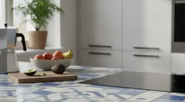 Carrelage d'une maison ancienne rénovée, avec une plaque de cuisson moderne et des fruits frais sur le plan de travail.