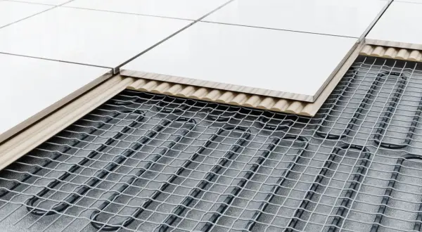 Vue en coupe d'un carrelage posé sur un système de chauffage au sol, montrant les câbles chauffants sous la dalle.