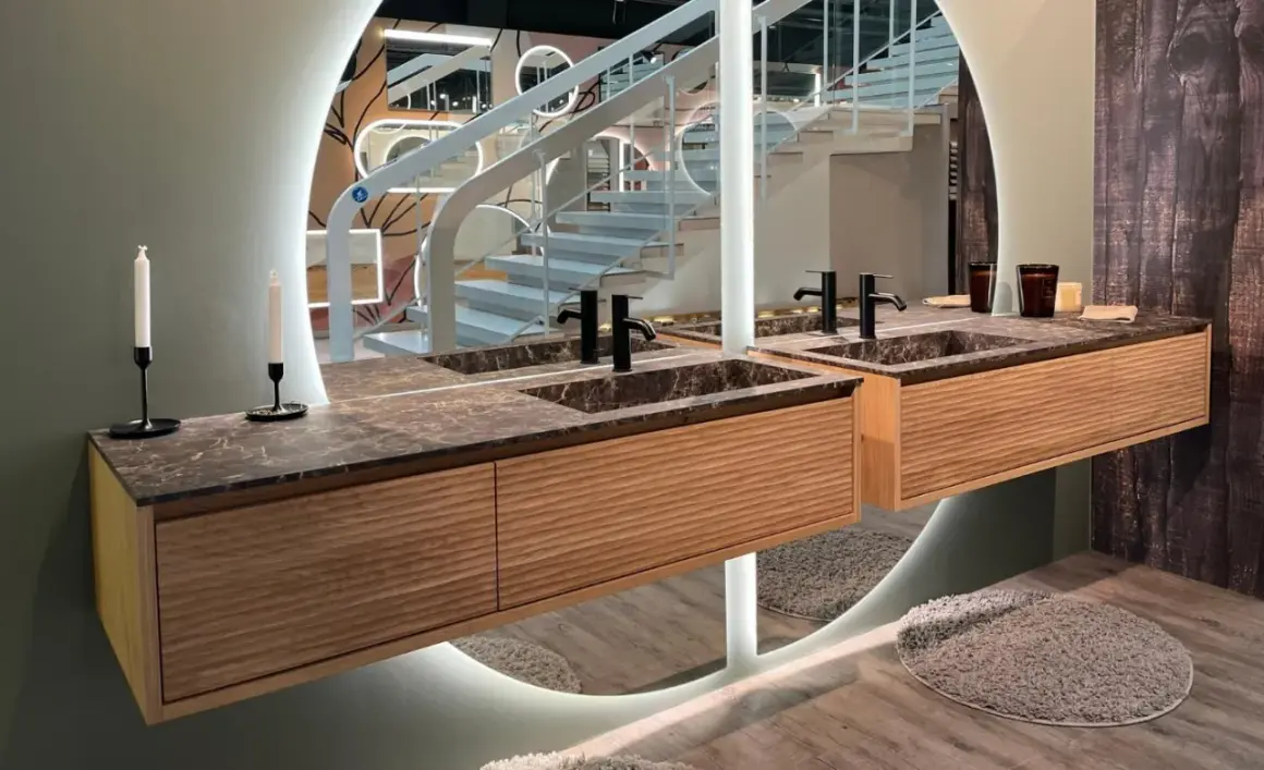 Une belle idée salle de bain marbre avec des meubles en bois et un grand miroir circulaire.