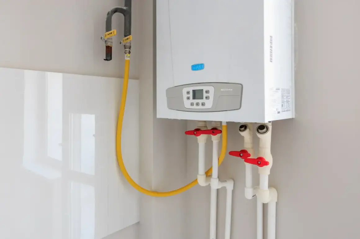 Installation d'un nouveau ballon d'eau chaude Baxi. Tuyaux de gaz et d'eau avec robinets rouges.