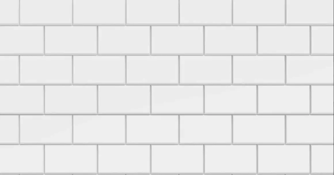 Vue rapprochée d'une pose carrelage métro blanche, avec des carreaux rectangulaires disposés en quinconce.