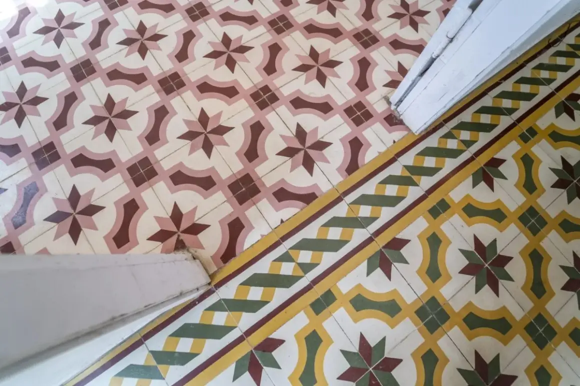 Un beau mélange de travertin et de carreaux de ciment aux motifs géométriques et floraux, créant une ambiance chaleureuse et authentique.