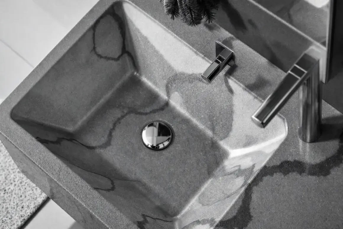 Lavabo évier moderne en béton gris veiné, avec robinetterie chromée. Un design épuré pour une salle de bain contemporaine.