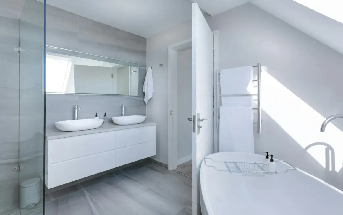 Salle de bain moderne avec double vasque, baignoire îlot et douche vitrée. Une belle idée rénovation salle de bain pour un espace lumineux et épuré.