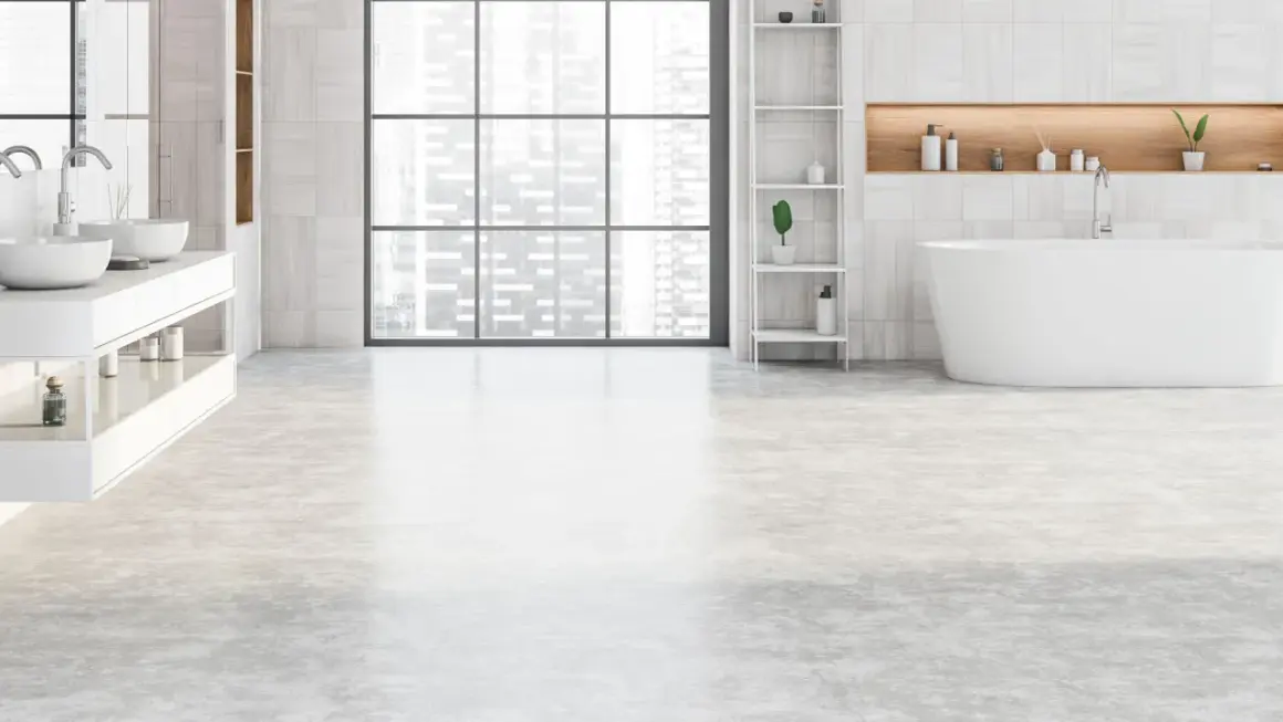 Salle de bain moderne avec baignoire îlot, double vasque et étagères. Le sol de la salle de bain est en béton ciré clair, apportant une touche contemporaine.