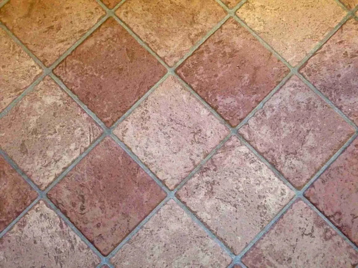 Carrelage mal posé, les carreaux de terre cuite sont de travers, créant un motif irrégulier et déroutant.