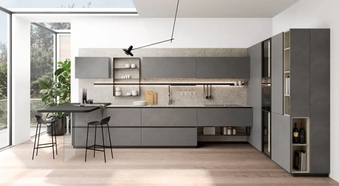 Plan cuisine en L moderne, gris, avec îlot, tabourets et grandes fenêtres.