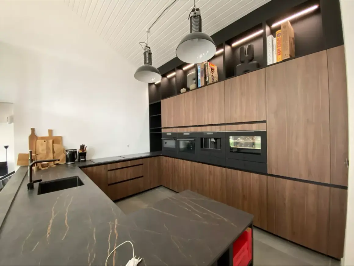Cuisine salle à manger et salon dans la même pièce. Design moderne avec îlot central, meubles en bois, et électroménagers intégrés.